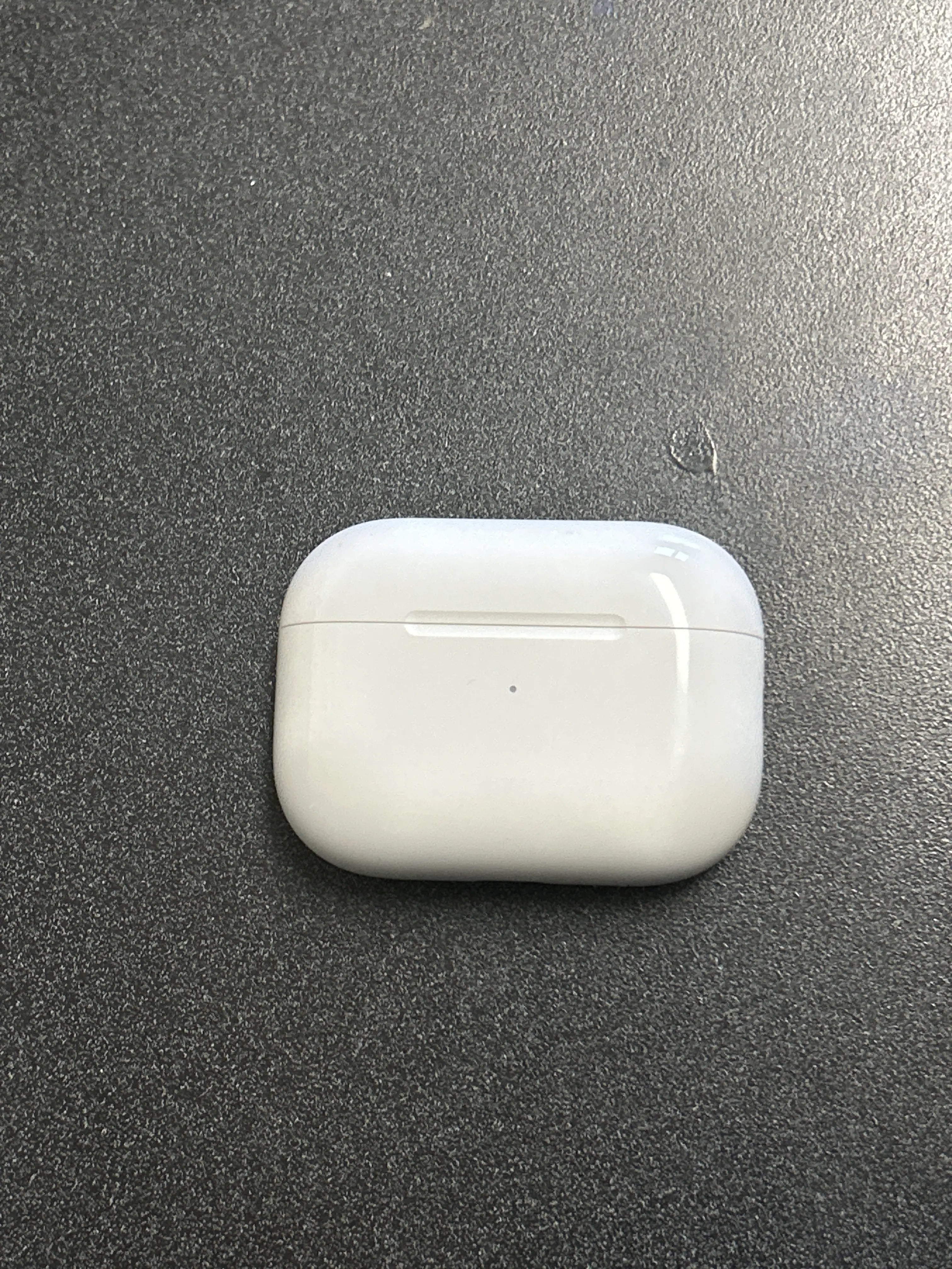 Weißes AirPods Pro Ladecase auf einer dunklen Oberfläche