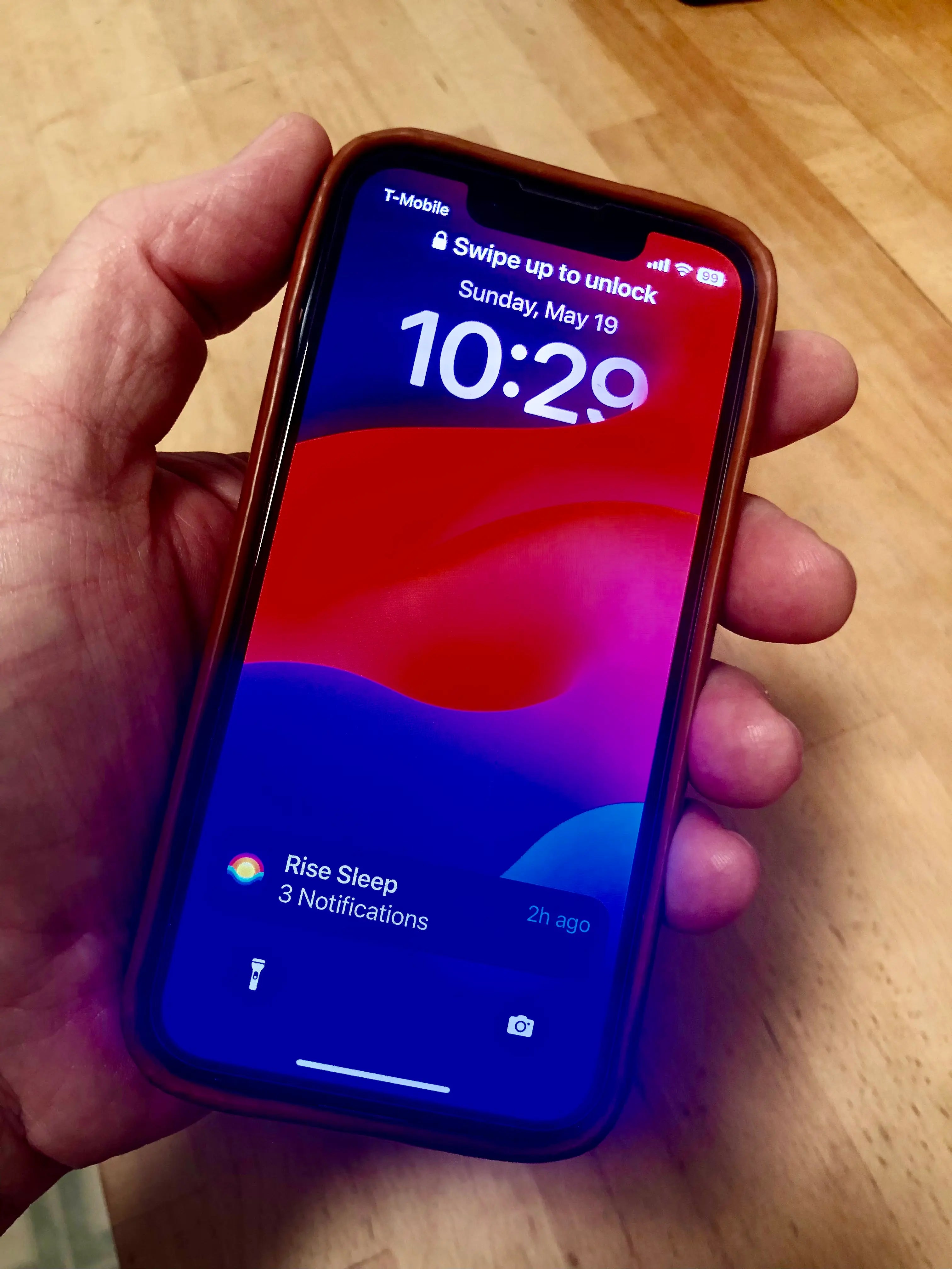 iPhone mit eingeschaltetem Display in einer Hand