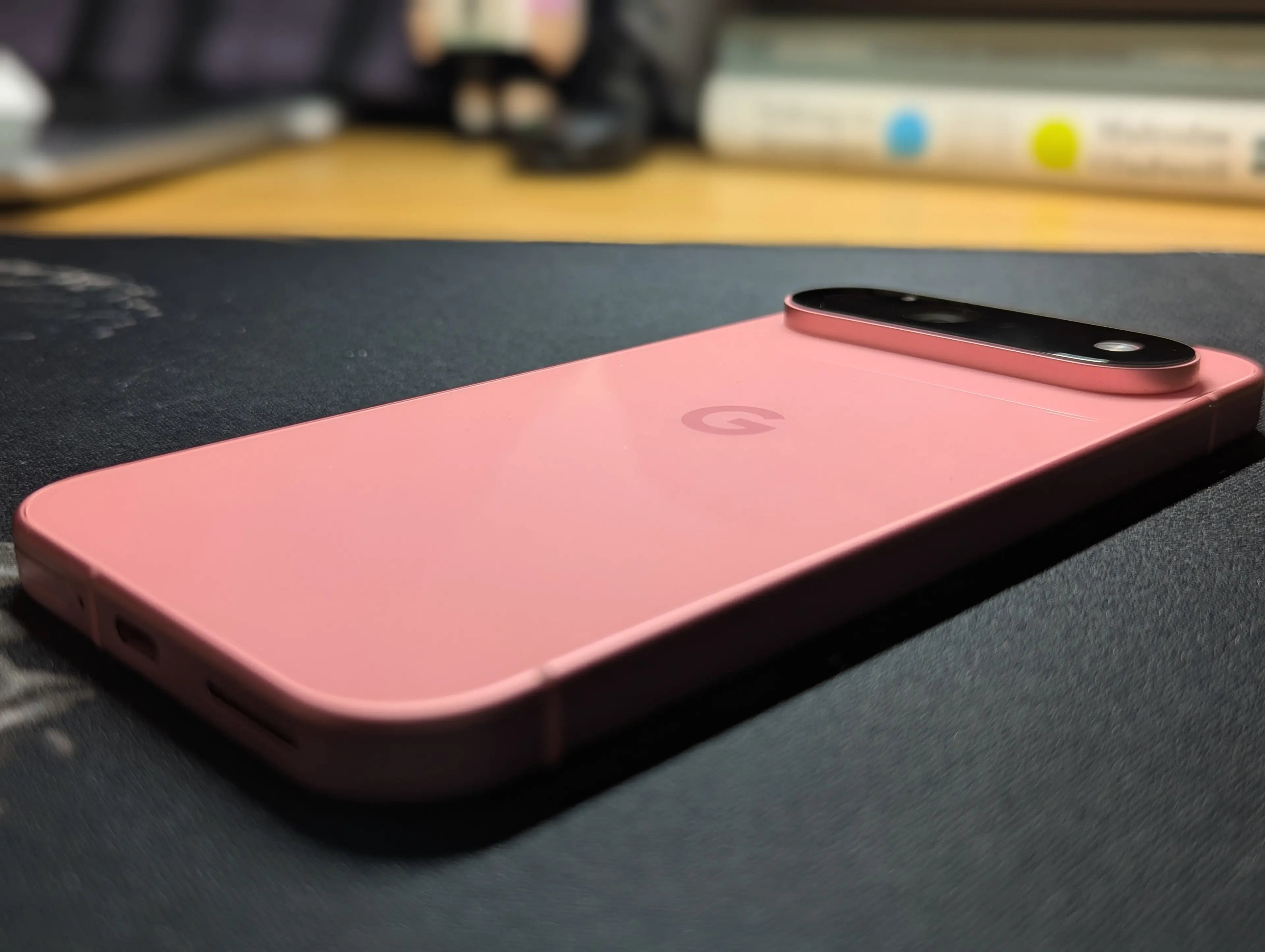 Rosa Google Pixel auf einer dunklen Schreibtischunterlage